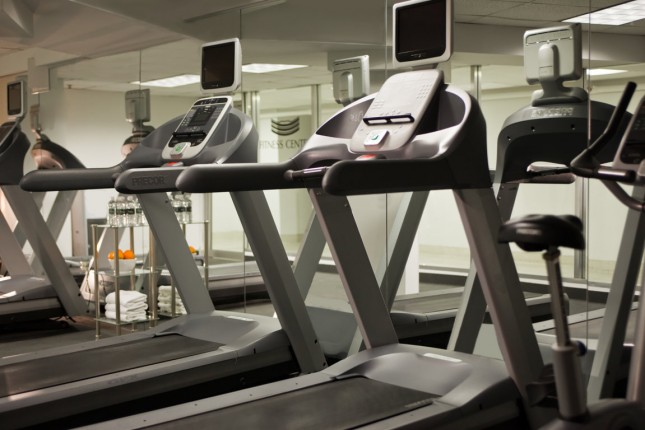 A gym with treadmills and an exercise bike in front of a mirror