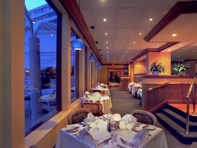 a long dining room with tables set for dinner